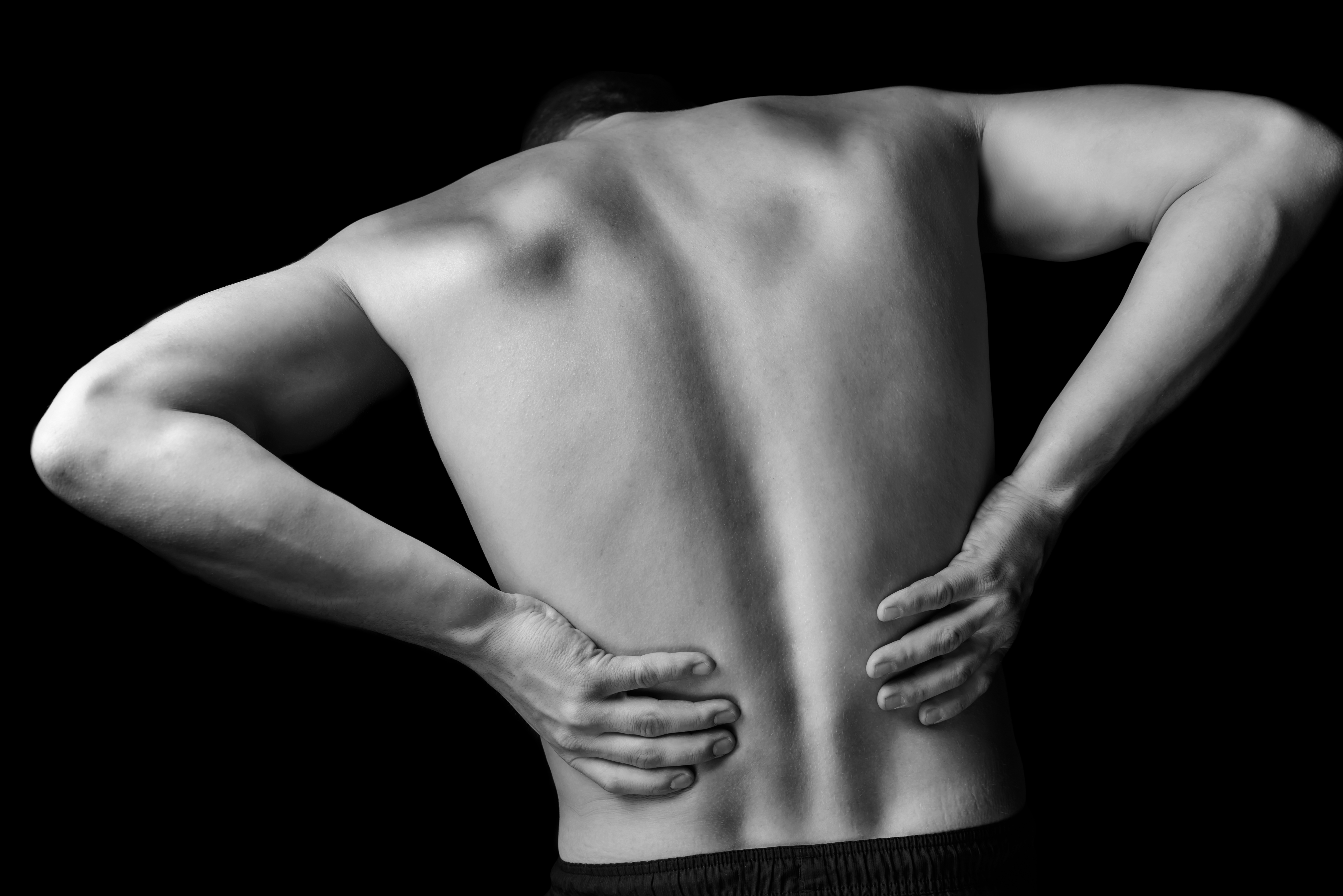 Acute pain in a male lower back, monochrome image